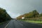 view from divers seat of the truck , wet road in front and collors of atumn