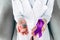 View of doctor holding model of brain and purple ribbon