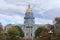 View of dome of Colorado State Capitol in Denver. American and Colorado flags waving in wind in front of the dome