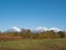 View of the domestic Kamchatka volcanoes against the background of the blue sky and autumn forest. Kamchatka Peninsula, Russia