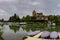 View of the Doubs River in Dole with the church on the hilltop and houseboats moored on the riverbank