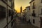 A view down the street of Antequera, Spain leading up to towards the Moorish Alcazaba palace fortress at sunset