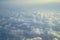 View of dreamy fluffy abstract white cloud with blue sky and sunrise light background from airplane window