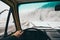 View from the driver seat over the snowy dirt road with winter forest on background