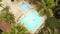 View from drone above tourist man relaxing in swimming pool. Aerial view young man swimming in blue water pool at summer