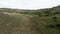 The view from the drone.Action.Huge mountains with frequent green vegetation on them against the background of a bright