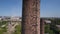 View from the drone. Ascent along the factory pipe. Ruins of factories in the background.