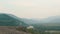 View from drone on the charming woman raising up hands while standing on the edge of the mountains.