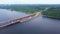 The view from the drone. Clip. A huge southern bridge on which cars drive is surrounded by water by a forest and