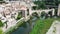 view from drone of fortified village of Besalu with Fluvia river and medieval arched bridge, Spain