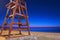 View of a dusk beach and starry sky with red wooden rescue tower