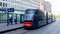 View of Dutch grey with red R-Net tram in front of the Dan Hague centraal train station loading passengers