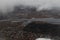 View of the earth from an airplane. At the top of the white clouds at the bottom of the river, cottages, forest, river pier.