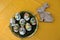 View on easter eggs and a wooden easter bunny on a yellow tablecloth