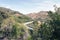 A view of an elevated tram rail and a highway passing cars in Los Angeles, California