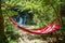 view of empty hammock between trees waterfall on background