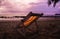 View on empty isolated deck chair on tropical beach during sunset with palm tree - Thailand, andaman sea