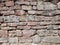 View of empty, old white, pink and grey brick wall background with copy space. A deteriorating old brick wall outdoors in sunlight