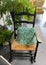 View on empty old wooden rocking chair with green cushion, plants in german living room