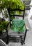 View on empty old wooden rocking chair with green cushion, plants in german living room