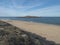 View of empty Praia da Ilha do Pessegueiro sand beach with ocean waves and Fort of Pessegueiro small island at Rota