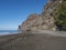 View of empty sand beach Playa de Guigui with rocky cliffs in west part of the Gran Canaria island, accessible only on