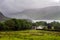 View of Ennerdale Water in the clouds in summer and of a typical farmhouse, Cumbria, England