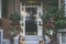 View of an entrance to apartment building. Stoop with plants, flowers and pumpkins for Thanksgiving Holiday