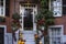 View of an entrance to apartment building. Stoop with plants, flowers and pumpkins for Thanksgiving Holiday