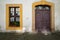 A view of the entrance to the townhouse. A large ornate wooden door and on the left a large sized window.