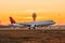 View of the evening airport and sunset, airplane taking off in the background with a control tower