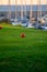 View on evergreen grass field on large golf course, green section with big red foam balls for beginners and yachts on Tenerife