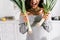 View of excited woman holding leek in kitchen