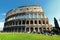 View of the exterior of the Colosseum in Rome with green lawn in front on a spring day