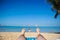 The view from the eyes of a man who is lying on the sand and looks out at the sea and you can see his feet