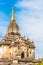 View of the facade of the building of the Shwegugyi temple in Bagan, Myanmar. Copy space for text. Vertical.