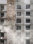 View of the facade of a multi-storey concrete monolithic building under construction. Fences and metal structures on the