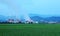 View of a factory in the middle of a green farmland in the early morning twilight