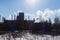 View of the factory with smoke from the pipe edge of the forest winter sun day