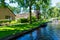 View of famous Giethoorn village with canals and rustic thatched roof houses.