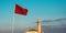 View of the famous Hassan II mosque and a waving moroccan flag