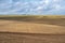 View of farm across ploughed field