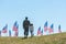View of father in military uniform holding hands with kid near american flags