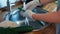 View of female hands in gloves washed fresh chives in kitchen sink.