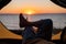 View of female legs in a tourist tent at sunset on the beach. The woman is hiking and camped on the riverbank.