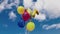 View of festive balloons for child  birthday of child developing in  wind against blue sky with white clouds.