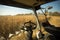 View of the field of corn from the cab of a combine harvester on a sunny day. Workplace of a combine operator. Theme is