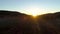 View of field with dawn rays of sun. Shot. Top view of rays of rising sun on green field with morning fog