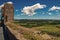 View of fields and hills of Tuscany from above the walls of the Monteriggioni hamlet.