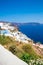 View of Fira town - Santorini island,Crete,Greece. White concrete staircases leading down to beautiful bay with clear blue sky